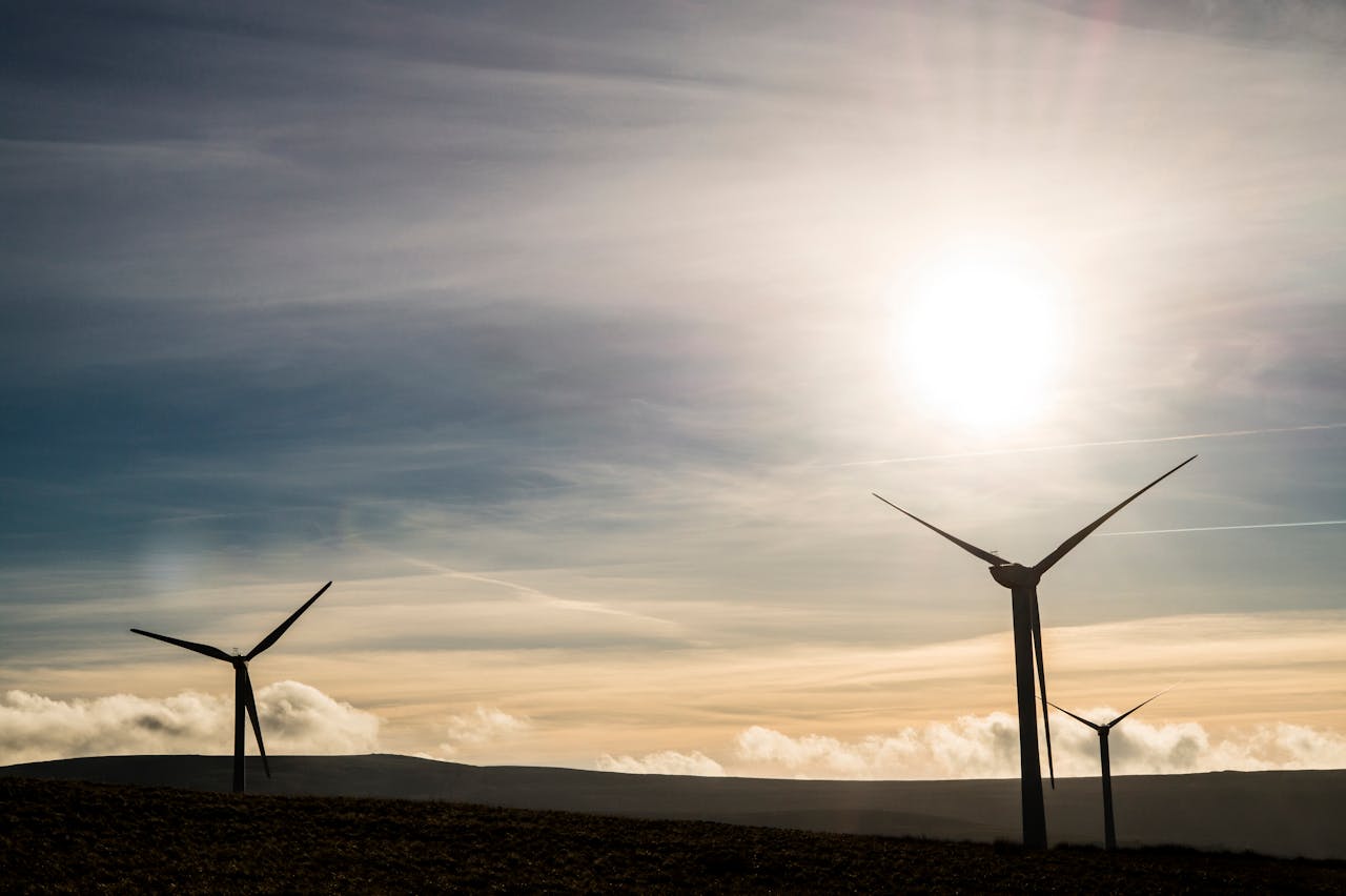 Silhouetted wind turbines generate renewable energy against a stunning sunrise sky.